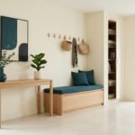 Entrée moderne avec console en bois clair, banc de rangement, décorations aux tons bleu pétrole et vue sur jardin.