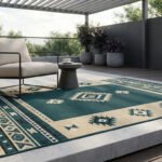 Tapis d'extérieur à motifs géométriques bleu et beige sur une terrasse moderne avec fauteuil et plantes.